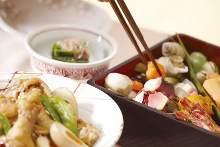 重箱に入ったおせち料理とほうれん草のおひたし