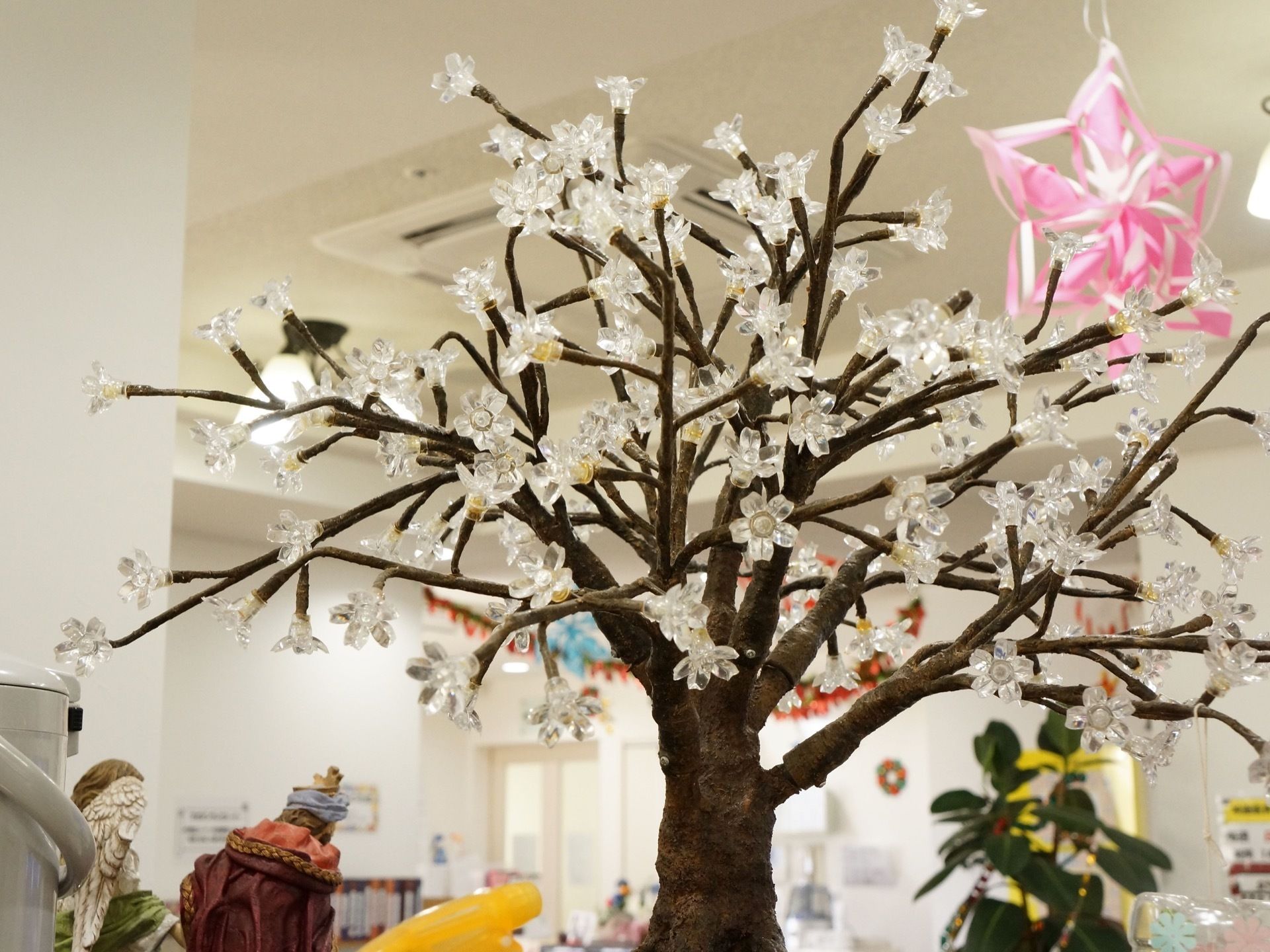 室内の木に、花をイメージした飾り物が付けられている。無数の花が付けられており、見るものの目を和ませている。
