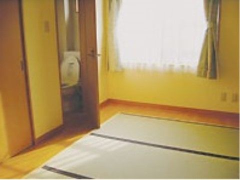 ドアが開いてトイレ内が見えている、畳敷きの和風居室