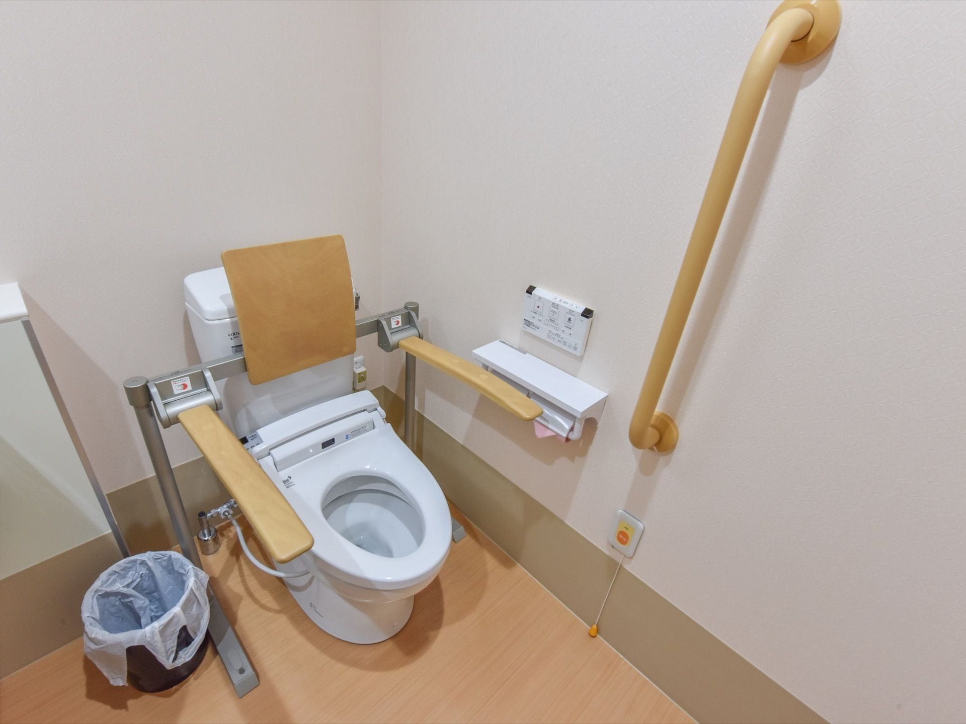 洋式便器の両側に可動式の手すりが設置されているトイレ