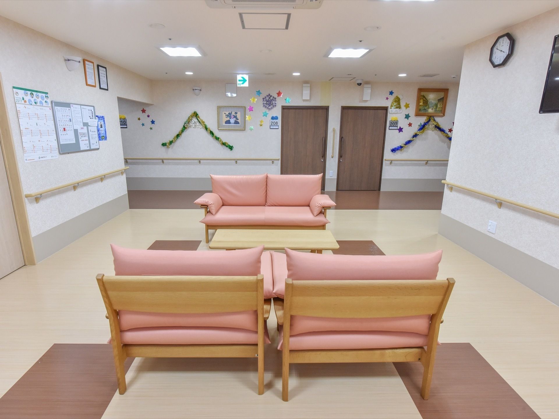 テーブルを挟み、ピンク色のソファーが三台設置されているリビング