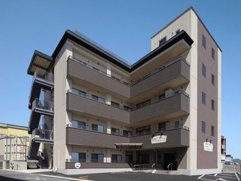 向かって左側に外階段が付いている、マンションのような外観の施設