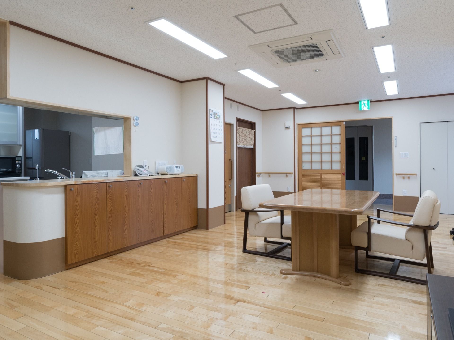 対面キッチンの前に、テーブルと白色の椅子が設置されているダイニング