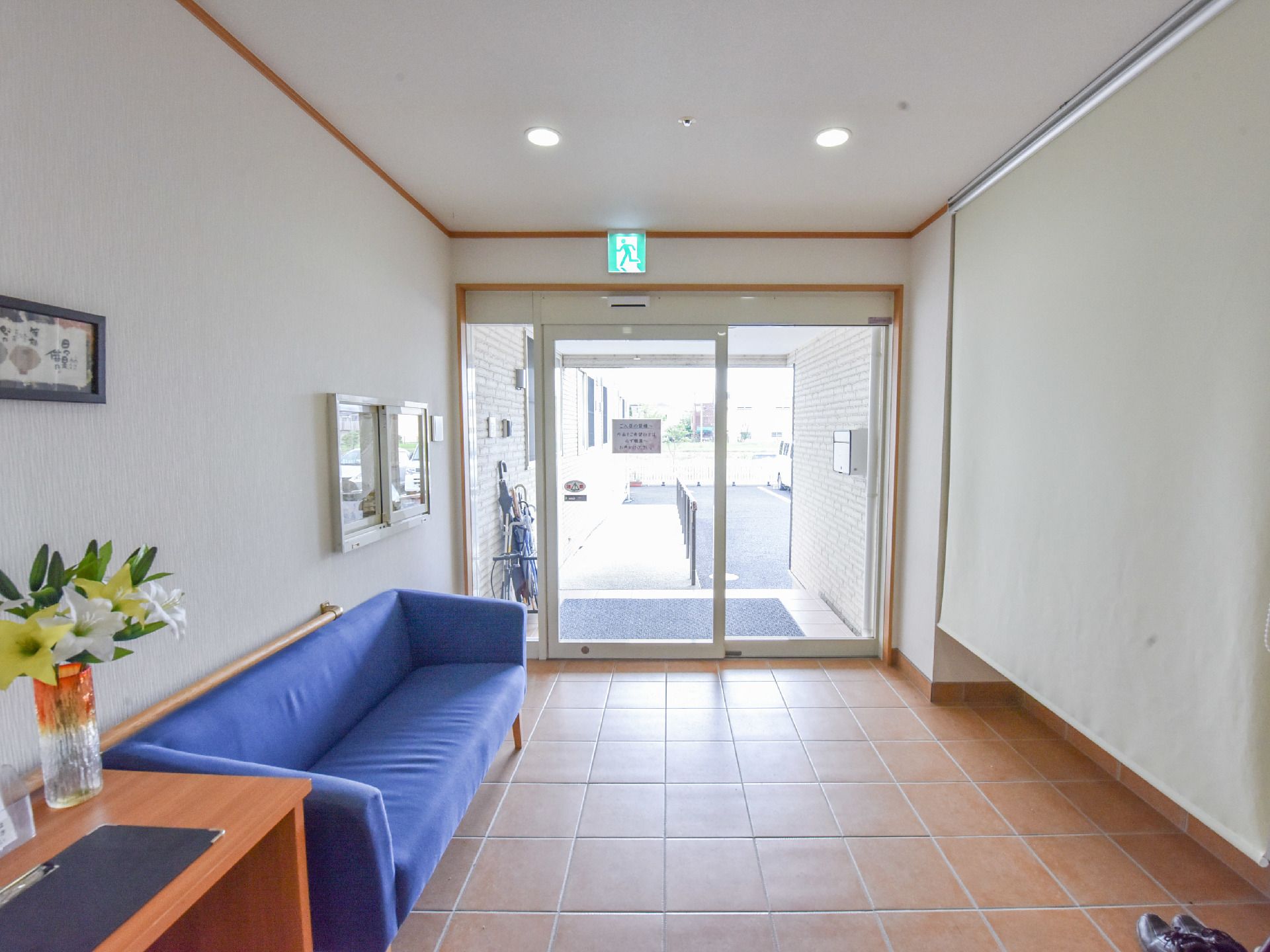 施設の入口は、ガラスの自動ドアで、バリアフリー設計になっている。入って右手に、青色をしたソファーが置かれいる。