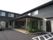 エントランスに花壇を設けた２階建ての建物