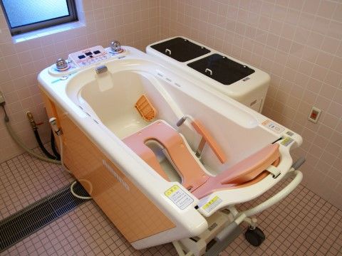 車椅子風の機器に座ったまま、入浴をすることができる大きな入浴補助機器