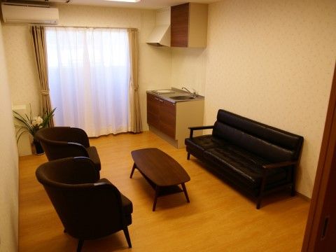 部屋の角に簡易式キッチンが設置されている共有スペース