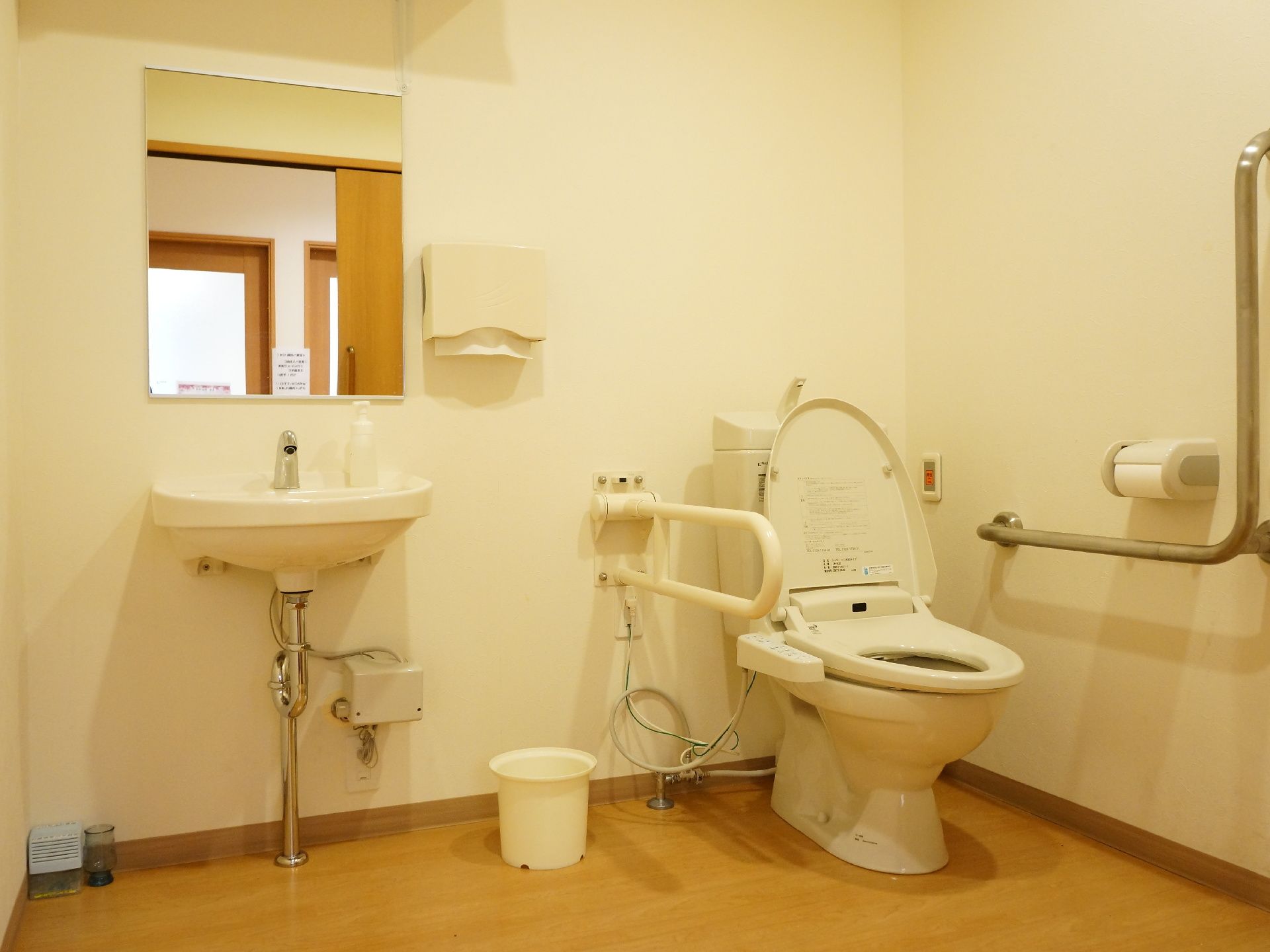 トイレは車椅子で入ることができる程広いスペースである。便器と手洗い場が併設されている。手すりが設置されている。