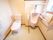 小便器が併設されているトイレである。便器周りには大きな手すりが備え付けられている。壁にはペーパーホルダーが取り付けられている。