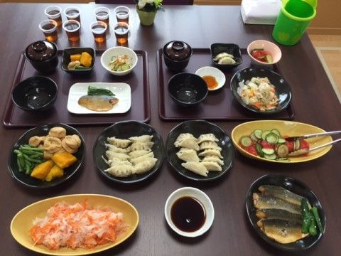 大皿に盛り付けられている料理と、お盆の上に小分けに盛り付けられた料理が置かれているテーブル