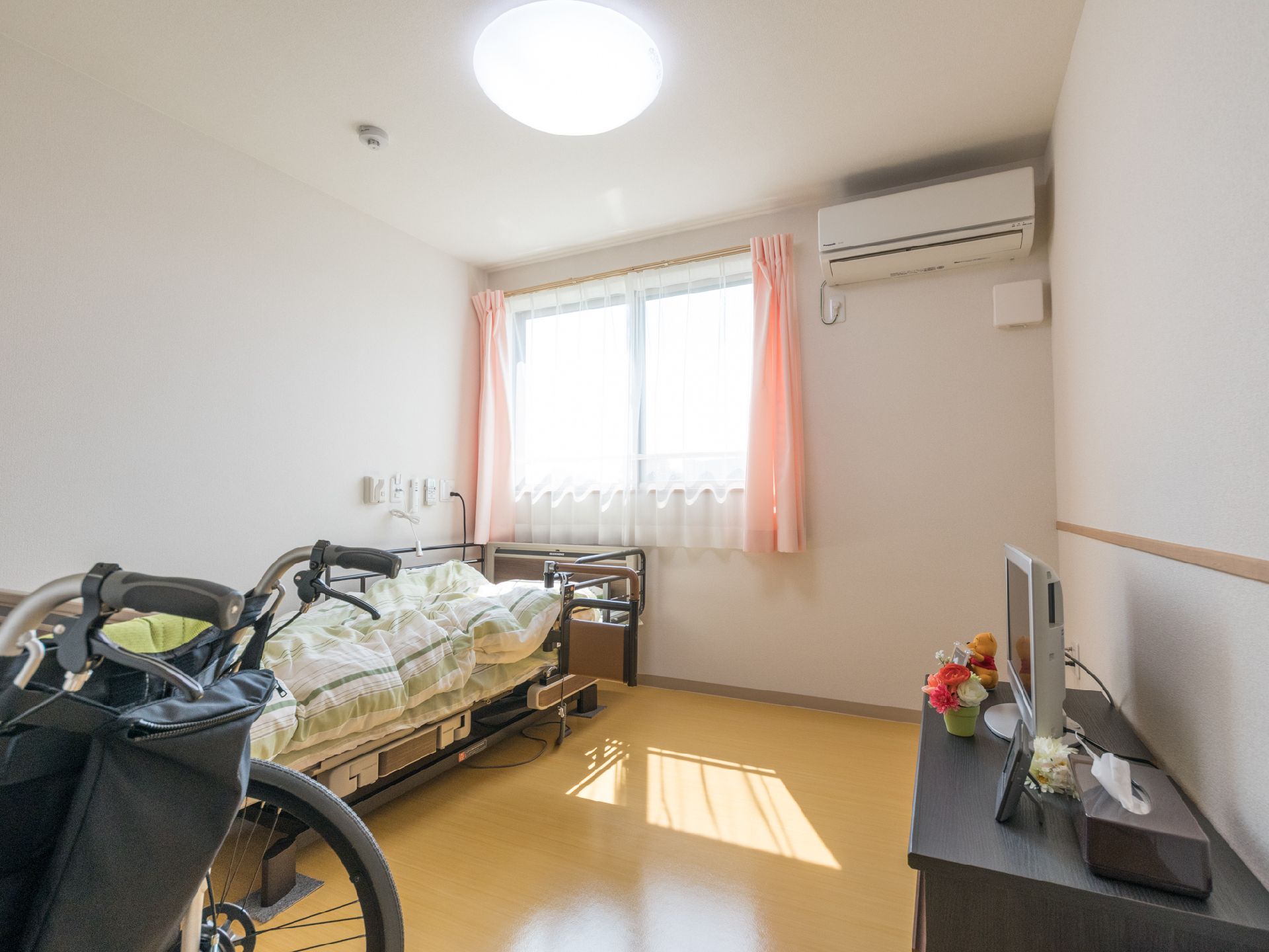 個室には窓が取り付けられていて、カーテンが掛かている。布団が置かれたベッドやテレビ台に置かれたテレビもある。