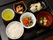 黒のお盆に食事が配膳されている。ご飯、豆腐のすまし汁、野菜の炊き合わせの他、白身魚など、バラエティ豊かな献立になっている。