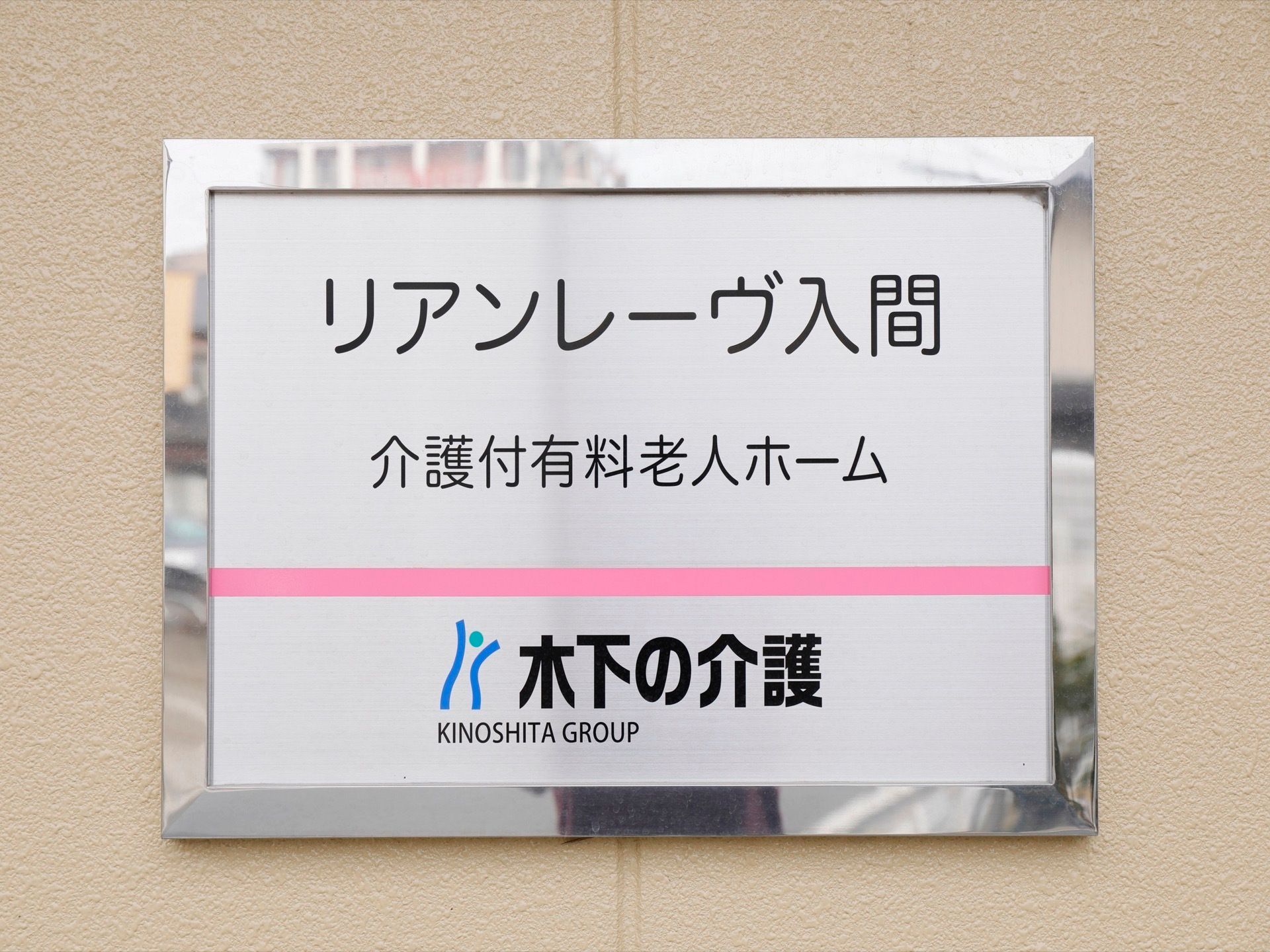 ベージュ色の壁に設置されている、施設の名称が記載された看板