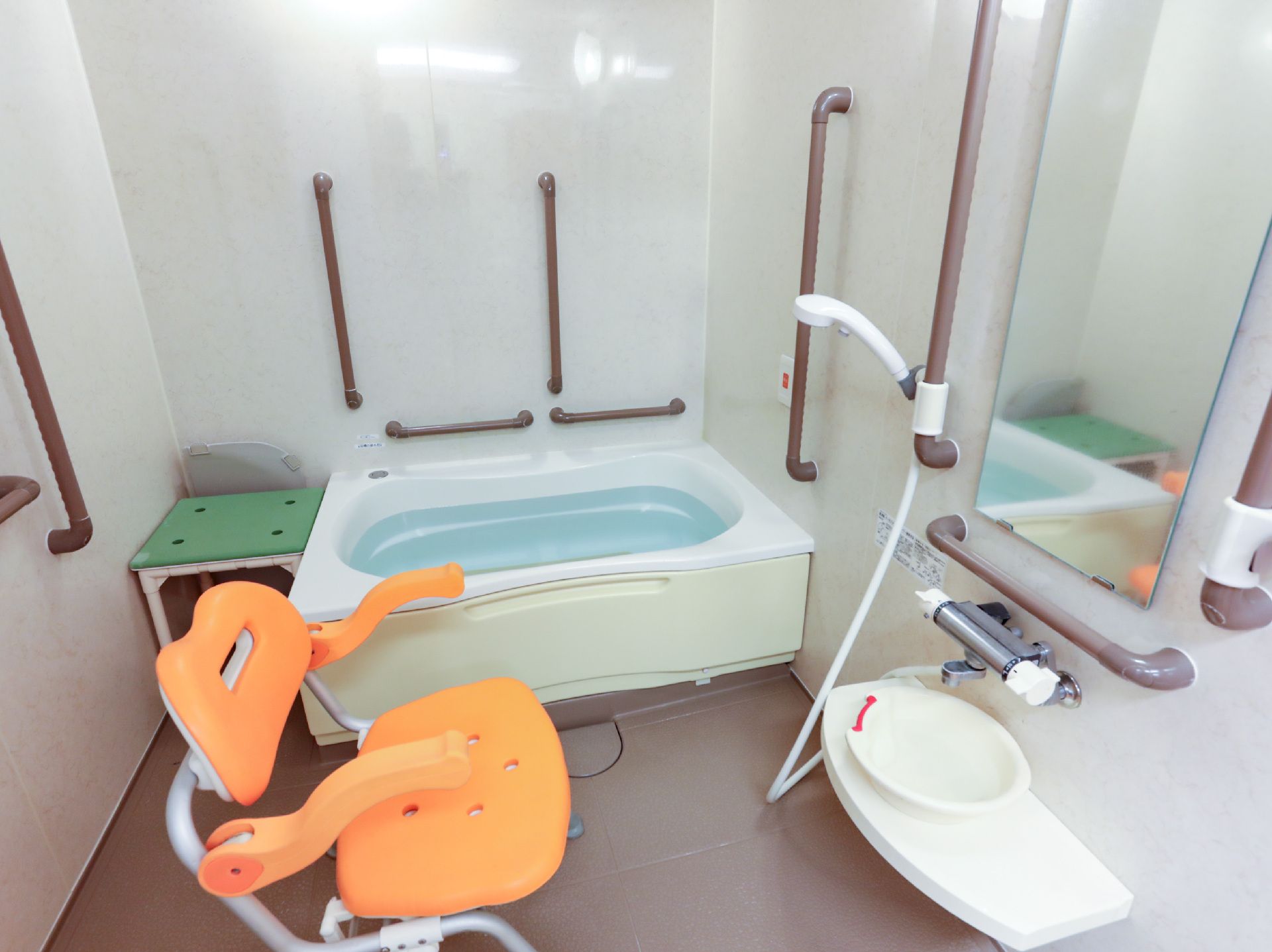 手すりが取り付けられ、落ち着いた色合いの浴室