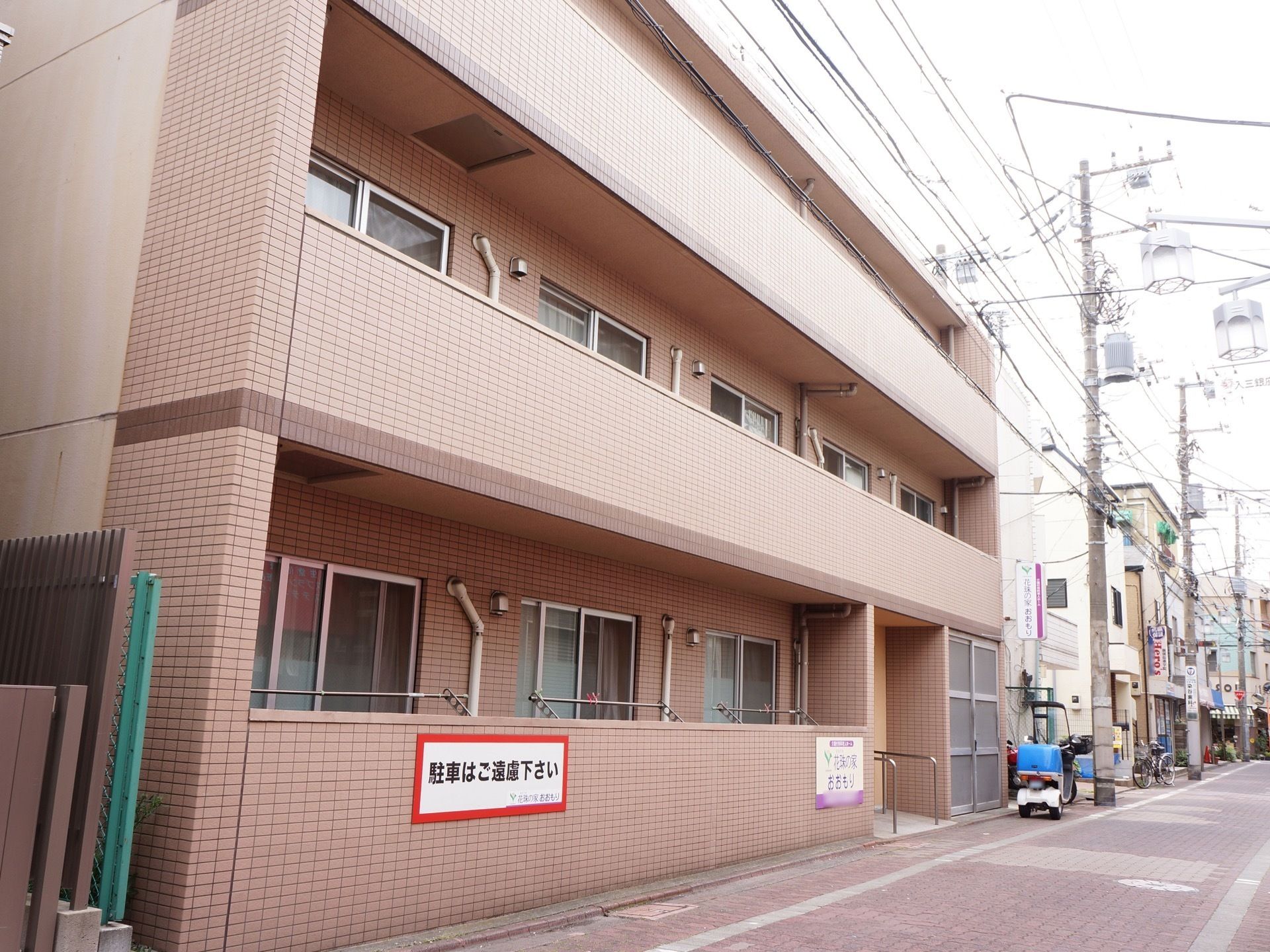 ３階建ての建物には各階ごとに大きなベランダが設置されている。ベージュ色のタイル張りの建物になっている。