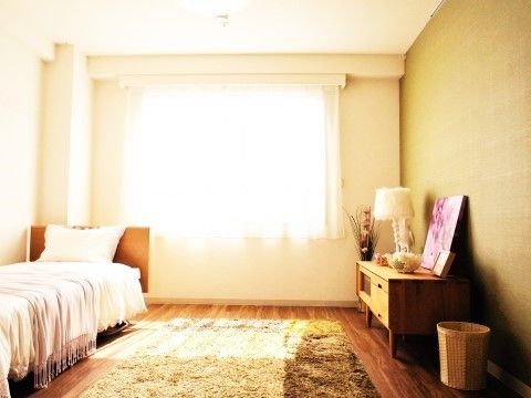 ベッドの横のフローリングに、カーペットが敷かれている居室