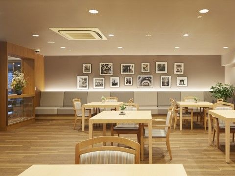 壁に白黒の作品がたくさん飾られている下に、備え付けのソファーが並んでいるリビング