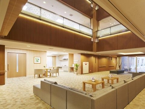 花が飾られた正方形のテーブル二台の周りに、L字型にソファーが設置されている玄関ロビー