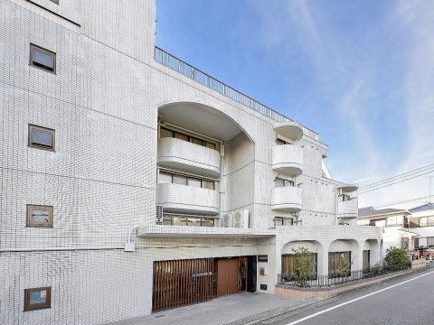 「住宅型有料老人ホーム ガーデンテラス座間」の外観。静謐な住宅地に佇む、大きめの老人ホーム。