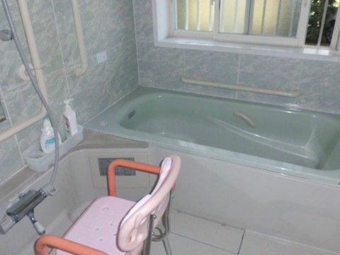 シャワーチェアに座って、シャワーが利用できるようになっている。シャワーの前に、数本の手すりを取り付けている。