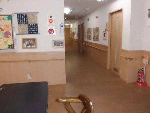廊下には手すりがあり、壁の一部やフロアは木目調の素材を使っている。壁のコルクボードに飾った写真や作品を見る時に、手すりが利用できる。