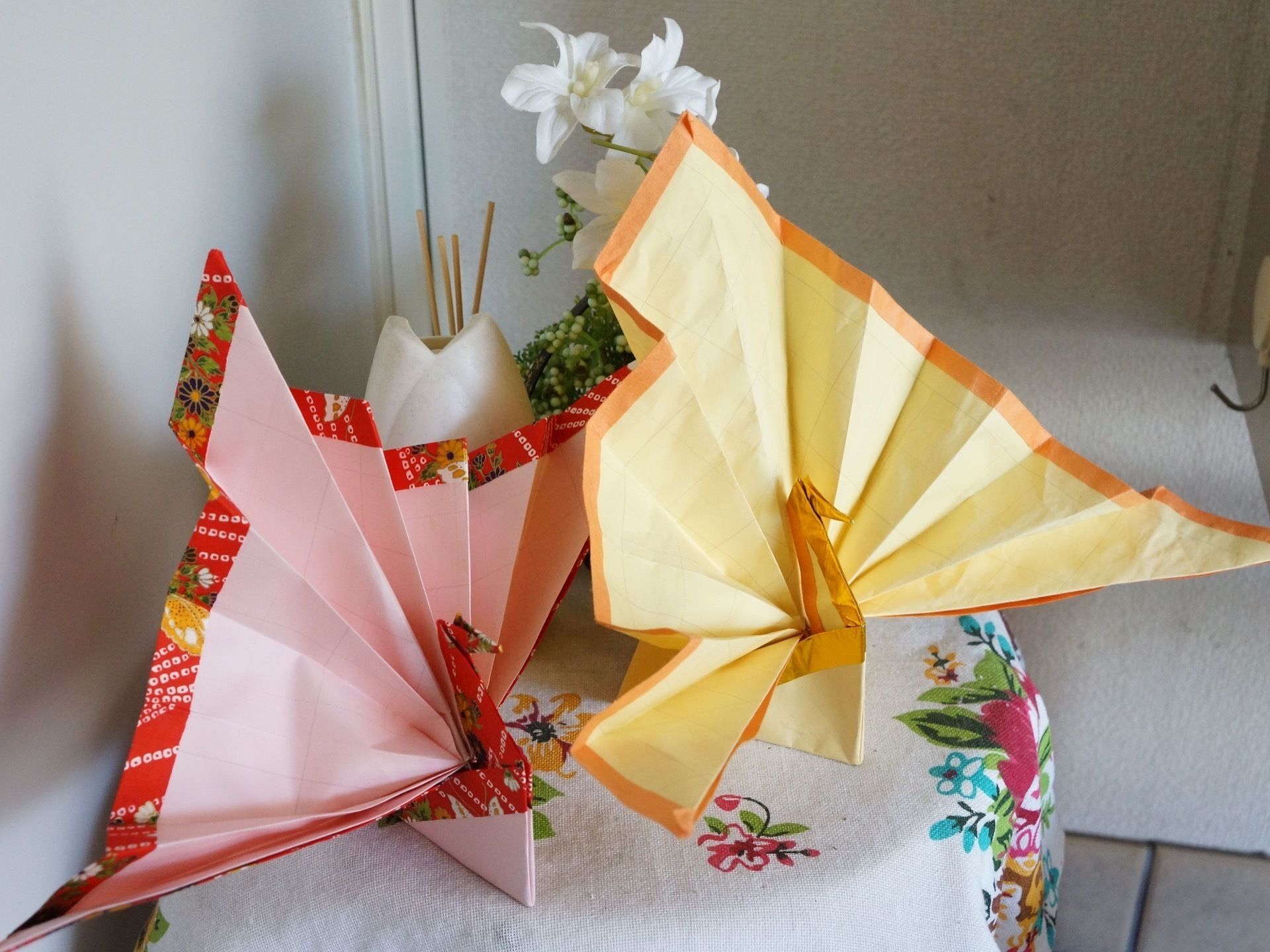 壁際にサイドテーブルが置かれている。テーブルの上に模様入りの布が掛けられている。また、クロスの上に小物が置かれている。