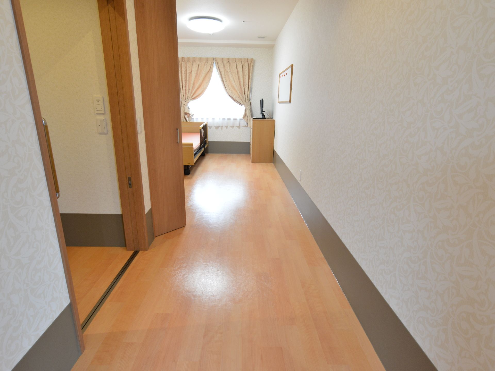 個室に入ると奥に向かって廊下がのびており突き当たりは窓になっている。入ってすぐ左は扉、その奥が部屋になっている。