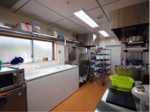 電子レンジや湯沸かしポットが置かれている、横長のキッチン