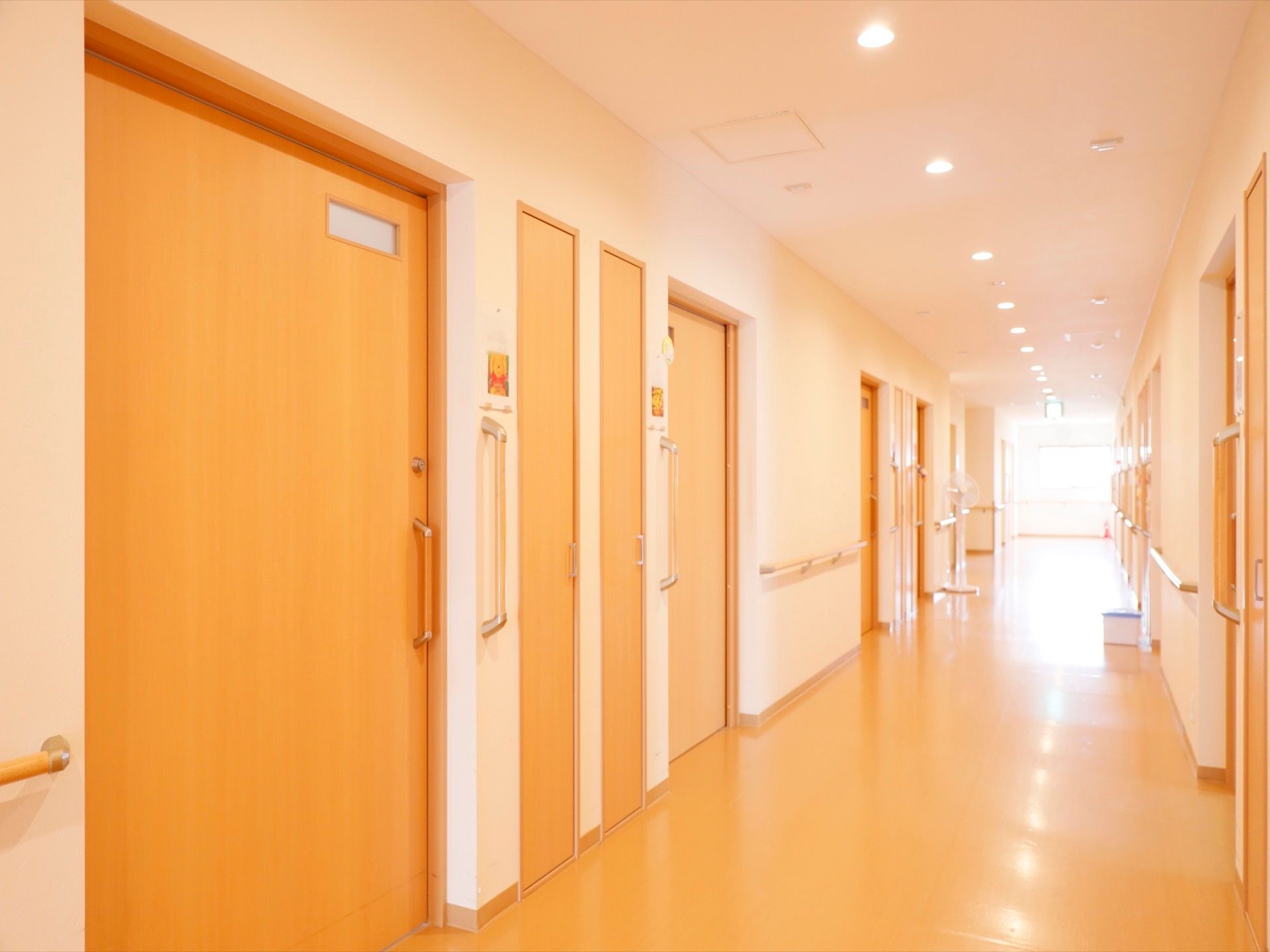 外の自然な光が差し込むため、大変明るい通路である。手すりを設置し、安全に歩行できる環境を整えている。