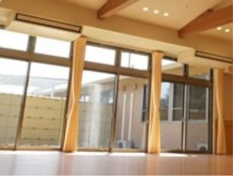 大きな窓に黄色いカーテンが付いている、広々としたスペース