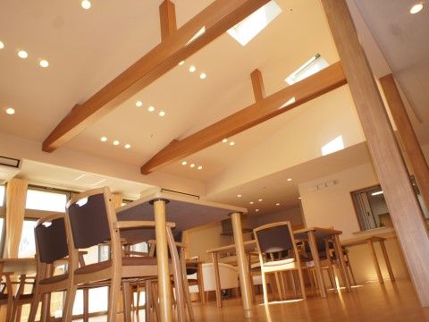 天窓から日差しが入る明るい食堂である。木肌色のしっかりとした梁が設置されており、お洒落な空間となっている。