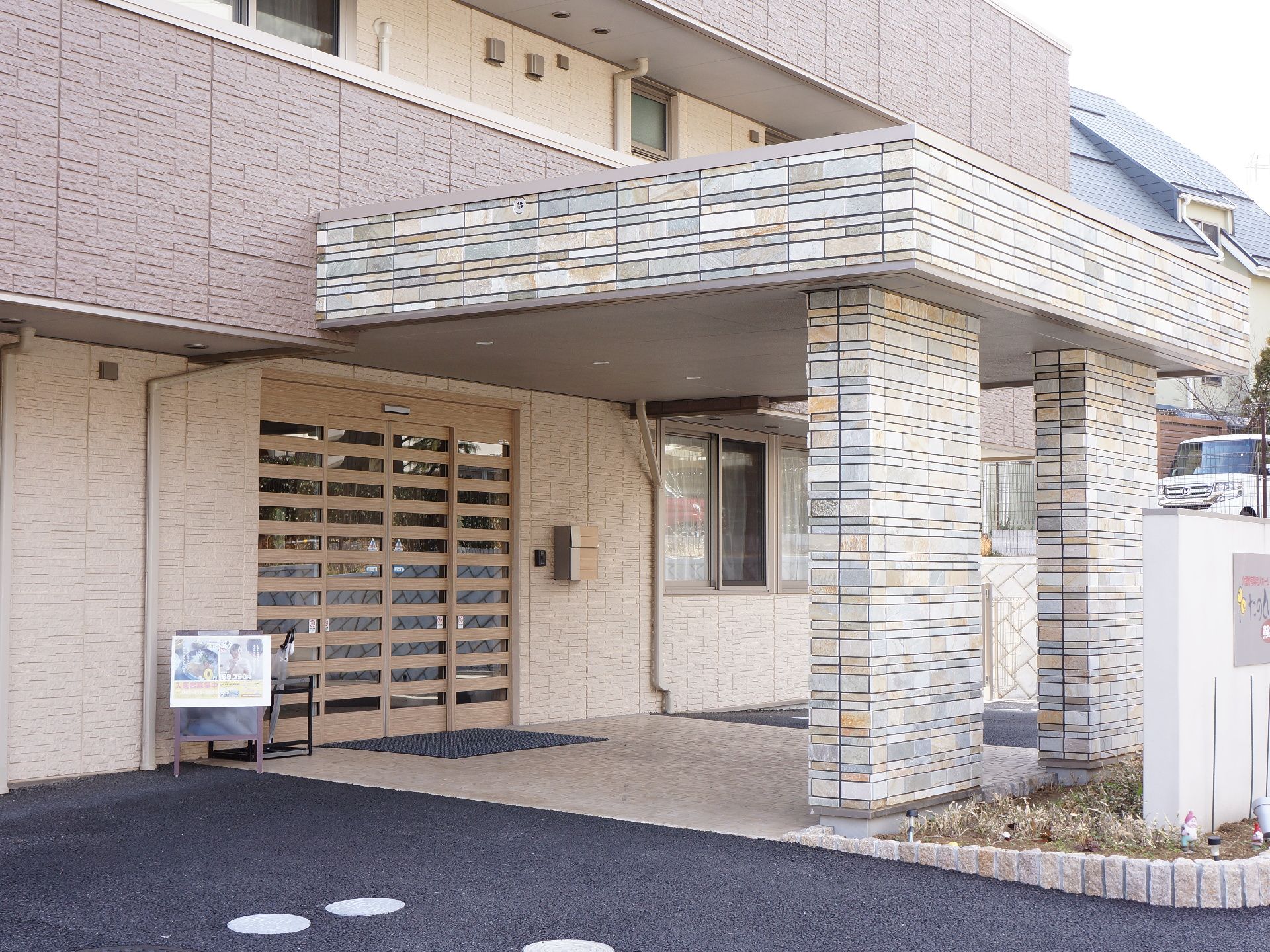 施設の出入り口前は車いすの通行がスムーズに行えるスペースが確保されている。扉は両開きの自動ドアである。