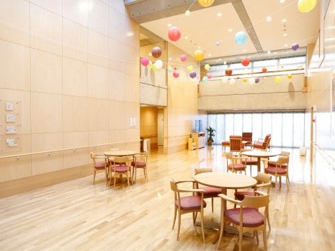 「メディカルケア センチュリーハウス溝の口」リビング・食堂。天井には、風船が飾り付けてあり、オシャレな空間を演出しています。