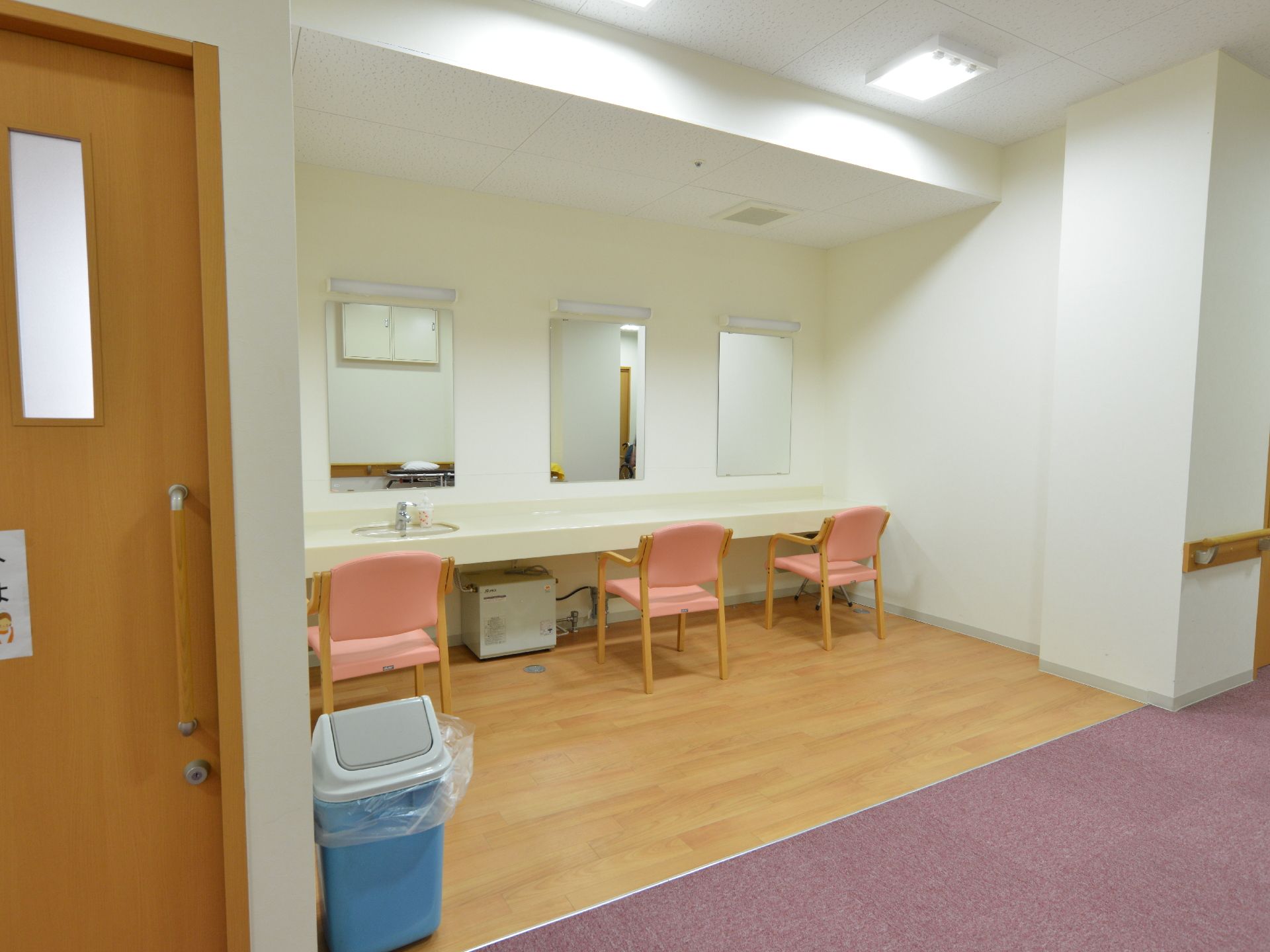 3枚の鏡が並んでおり、その前にそれぞれ椅子がある。そのうちひとつには洗面所が用意されており後方にはゴミ箱がある。