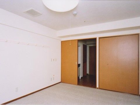 白い壁と天井で、清潔感のある広々とした居室である。壁には物を掛けることができるフックを設置しており便利である。