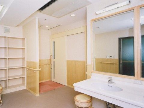 明るく清潔感のある脱衣スペースである。扉はスライド式になので安全に開閉することができ、段差がないので安全である。