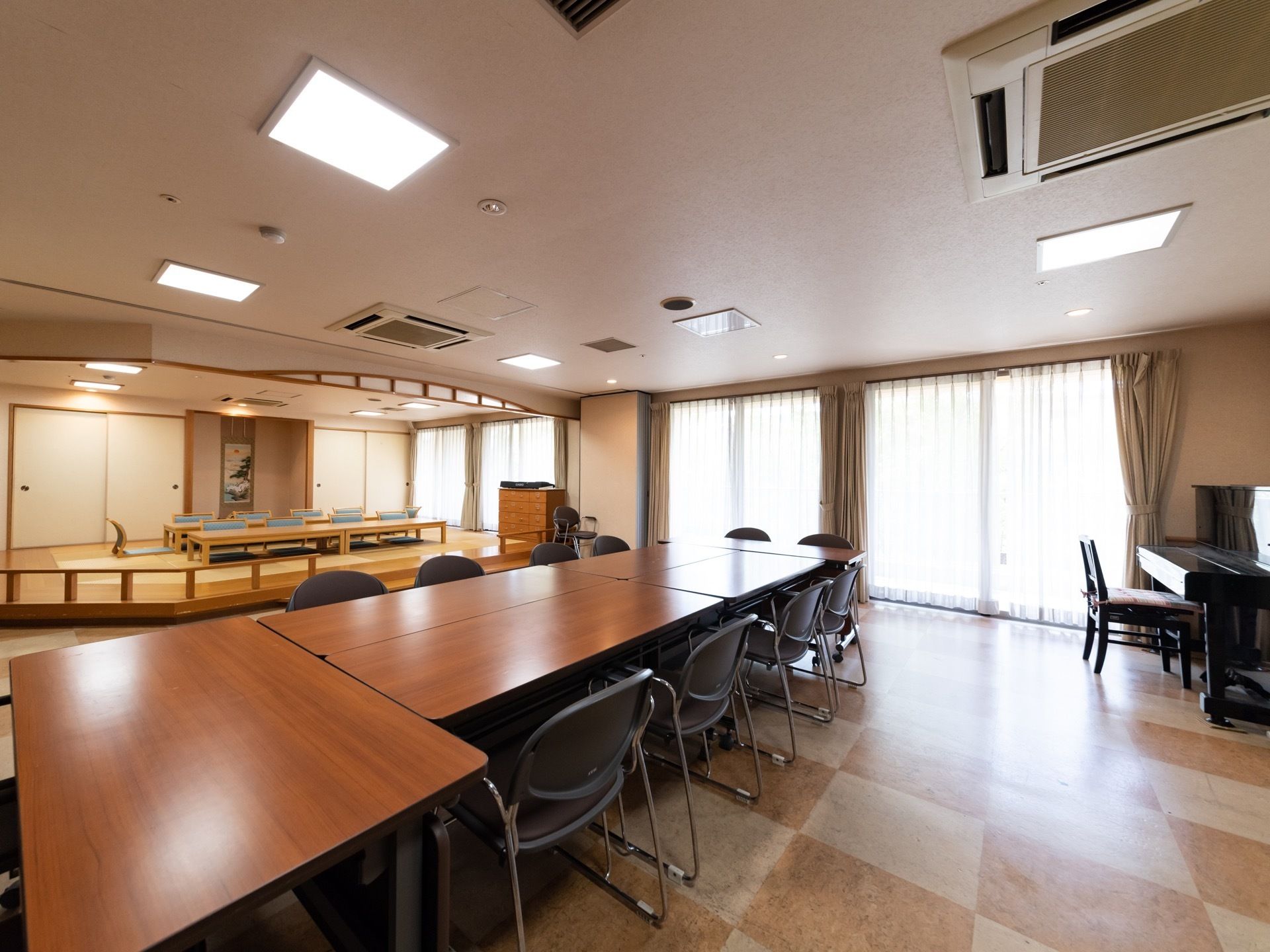 和室には床の間があり、両側に押入れがある。その前に机と座椅子が設置されている。手前の部屋は洋室でピアノが置かれている。