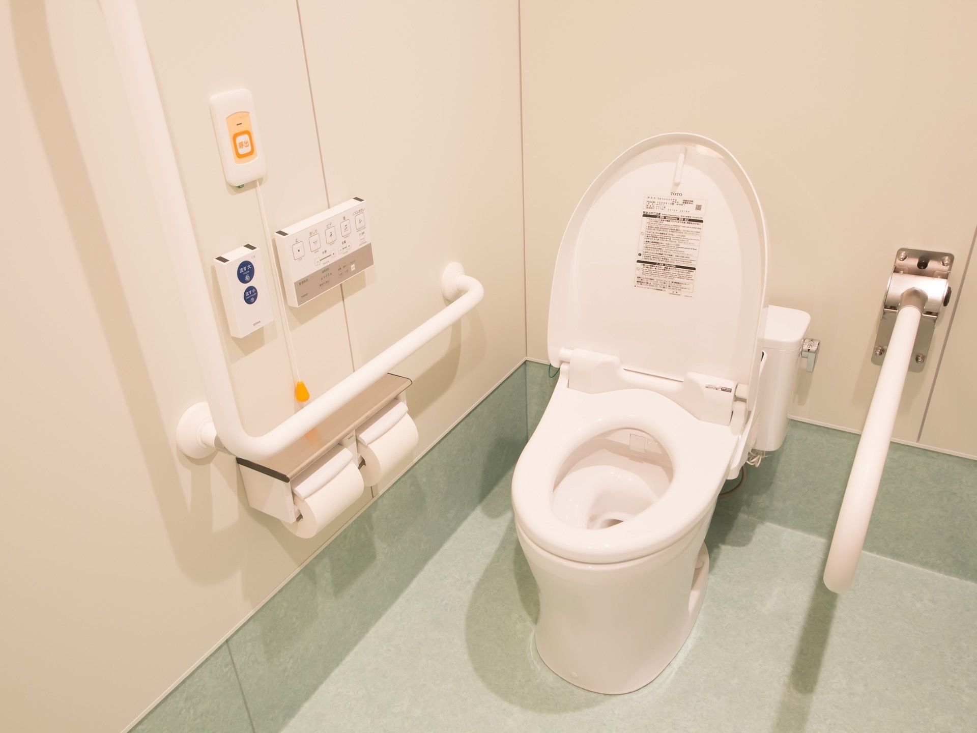 共用設備のトイレ。背中側の壁に折りたためる手すりが取りつけられていて、車椅子対応のつくりになっている。