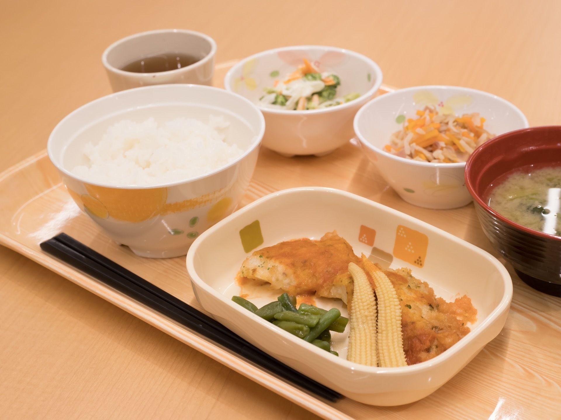 施設で入居者様に提供されている食事の一例である。白米と味噌汁を中心とした和食の献立となっている。主菜のほかに、副菜が２品ついている。