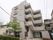 マンションのような外観の介護施設。エントランス前はつつじや植木がありきちんと剪定されて手入れが行き届いている。