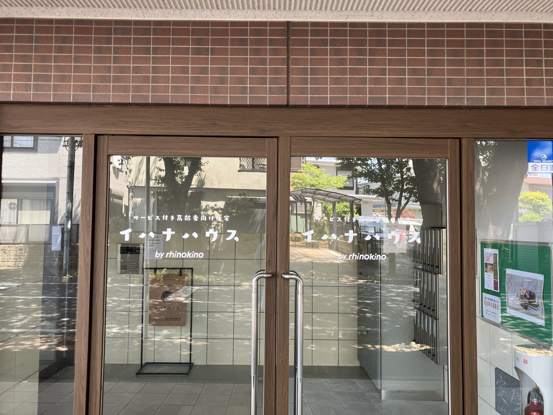 明るい光が差し込む建物の入り口は段差がない。オートロックを設置した扉は大きく、安心して通行することができる。