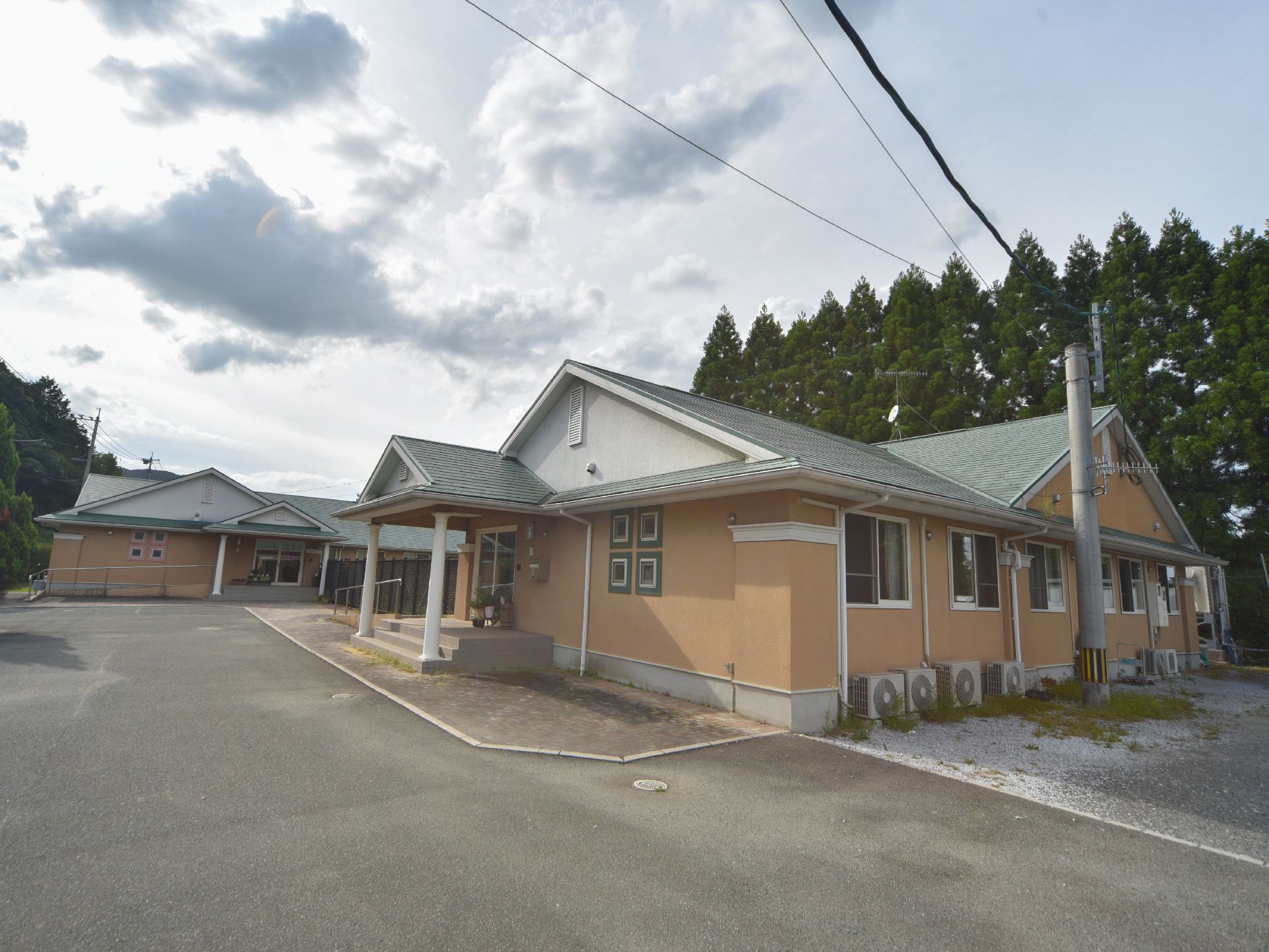 緑に囲まれて自然豊かな場所に 1階建てで建てられている。建物の周辺はコンクリートできれいに整備されている。