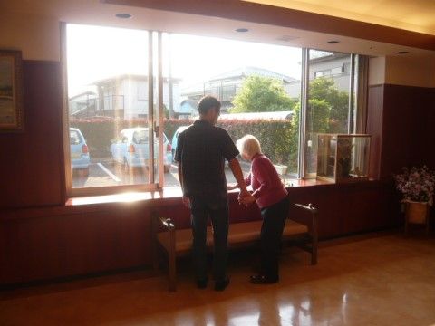 フローリングの床の部屋で、窓の近くに立っている男女