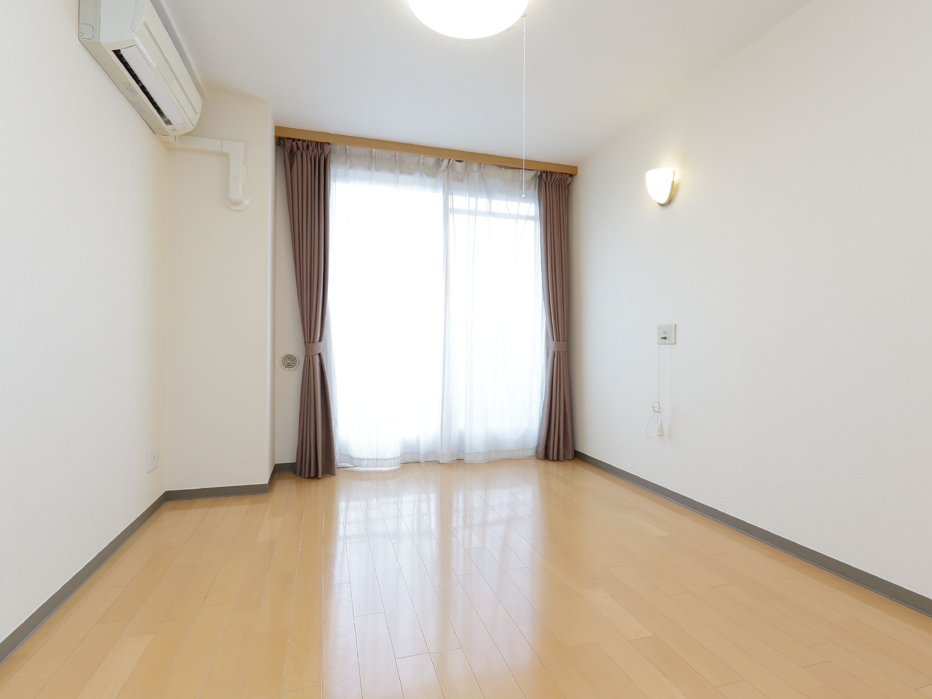 老人ホームの部屋は個室である。天井の証明と壁に間接照明が設置してある。エアコンが完備してある。ボックス式のカーテンルールが設置してある。