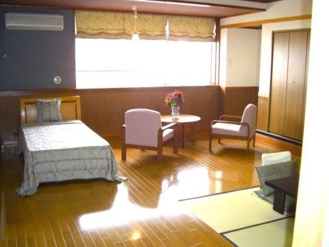 広いフローリングに一部畳の間がある明るい居室である。エアコンが完備されている。ベッド、和洋の机いす、収納スペースが備え付けてある。