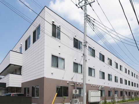 白と茶のツートンカラーが印象的な施設外観。日当たりが良く塀で囲われていないので、開放的な造りになっている。
