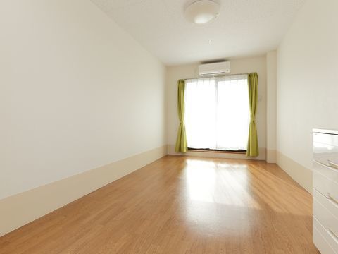 広々としたフローリングの部屋に、白いタンスだけが置かれている居室