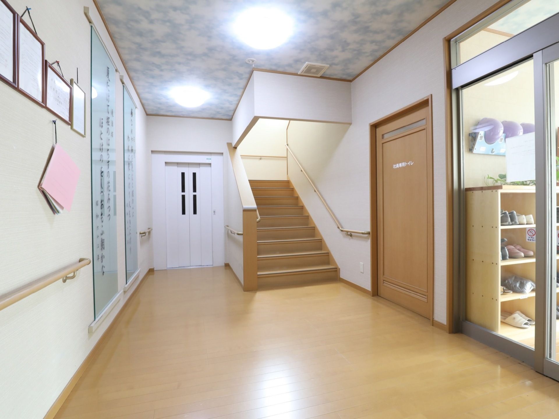 玄関から館内へ入ると、広く開放的なホールがある。右手には階段、白色のスタイリッシュなエレベーターが完備されている。