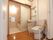 浴室のすぐ外には、洗面所とトイレが横並びに設置されている。部屋との境目には、白いアコーディオンカーテンが取りつけられている。