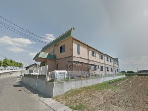 広がっている畑より高い場所に建設されている、施設の外観